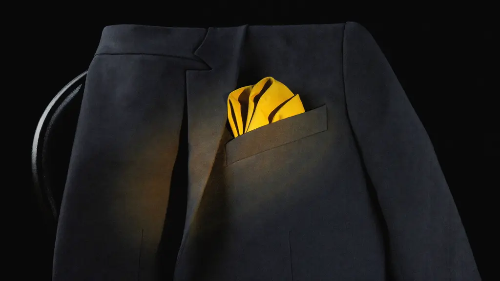 A tailored blazer with a gold pocket square under a warm spotlight