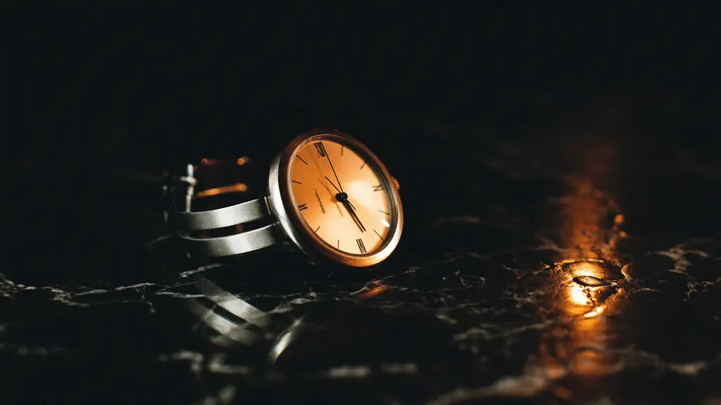 An elegant wristwatch on dark marble in warm candlelight